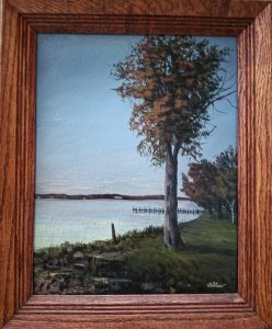 Autumn Sunrise on the Northeast River, framed acrylic painting by ASPIE artist David Allen of an autumn tree on a grassy riverbank at sunrise with an old pier